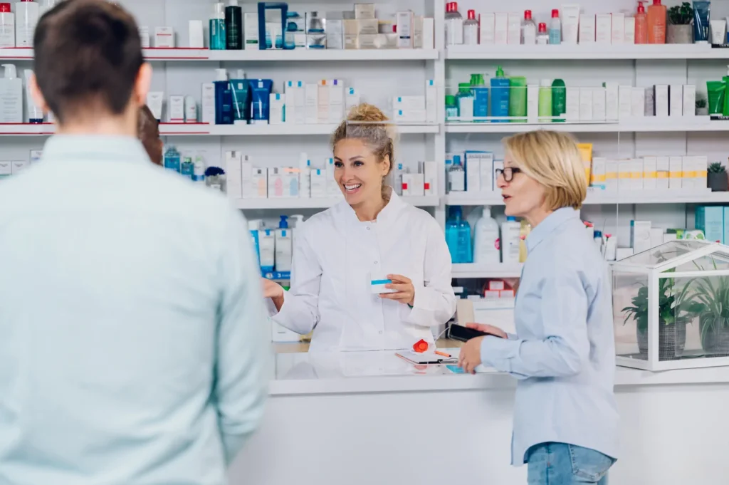Pharmacist assisting customers at pharmacy counter